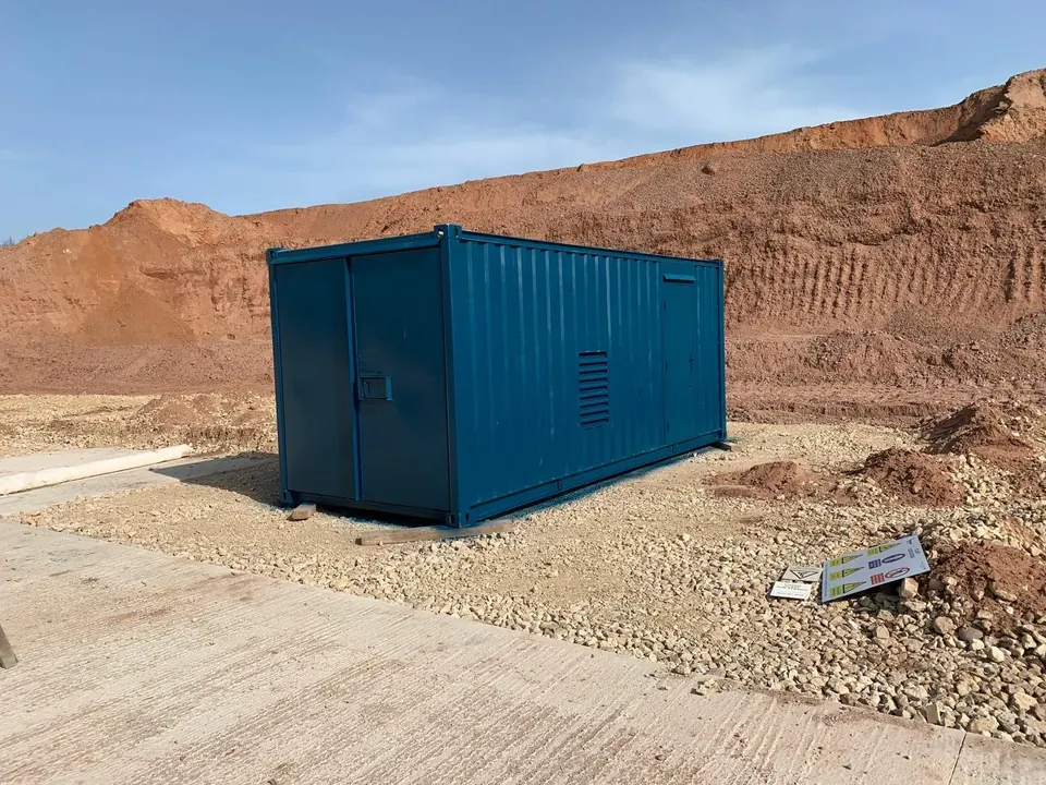 A steel welfare container blasted and repainted green on site at a quarry