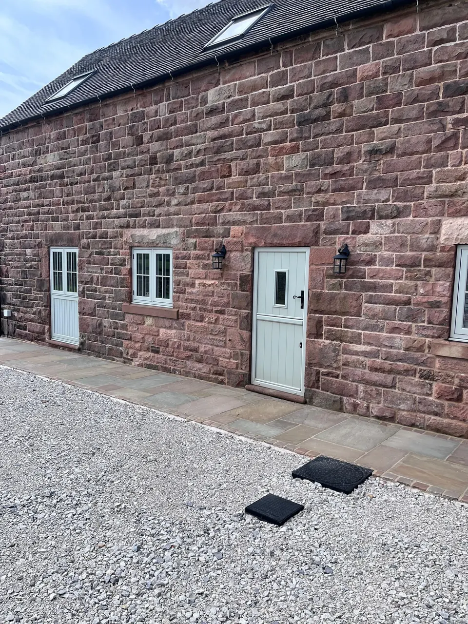 External sandstone wall of a cottage after blast cleaning, showing the natural red stone